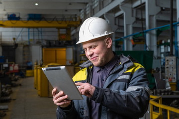 Fototapeta premium Engineer in a modern factory. The photo illustrates new technologies and production.