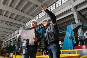 Two young engineers at a modern factory. The photo illustrates new technologies and production.