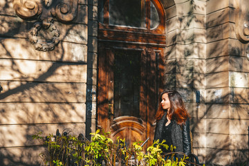 Architecture of Saint Petersburg, a girl with long hair stands at the entrance to the entrance of a historical building, plants everywhere