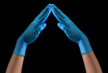 Doctor's hand in sterile medical gloves showing heart shape isolated on black
