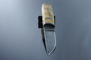 handmade carving knife on a mirrored surface, damascus blade, wood handle and damask steel spacers