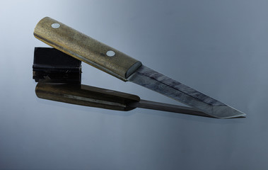 Japanese-style all-metal knife on a mirrored surface, handmade, damask blade, walnut handle
