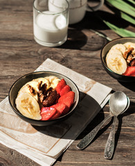 Healthy Vitamin Breakfast. Bananas, strawberries, nuts and dates in plates on a white background. Vegetarian and fitness food. Beautiful serving.