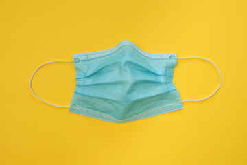 COVID-19 disposable surgical face mask on yellow background. Protection against coronavirus and...
