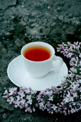 Obraz na płótnie Canvas a Cup of tea in the garden with flowers