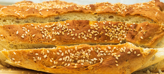 Bochenek chleba, dorodny, duży upieczony w domu. Chleb z ziarnami na drewnianej desce na białym tle