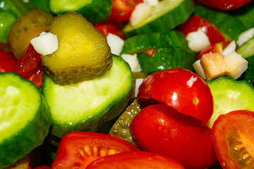 Vegetable salad sliced tomatoes, cucumbers, onions and pickles. Close up. Healthy food, fitness diet.