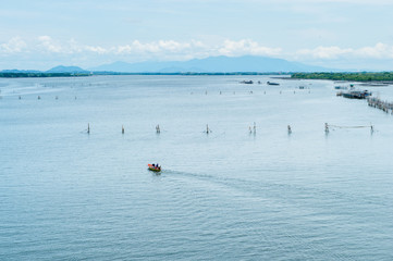 Fototapeta na wymiar Boat running on the sea with fisherman's farm