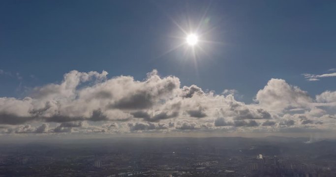 Aerial hyperlapse of clouds moving bellow the sun over city. Sao Paulo, Brazil
