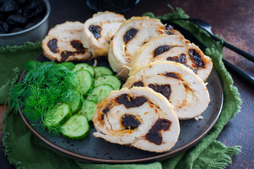 Chicken roll with prunes with fresh cucumbers and herbs, selective focus