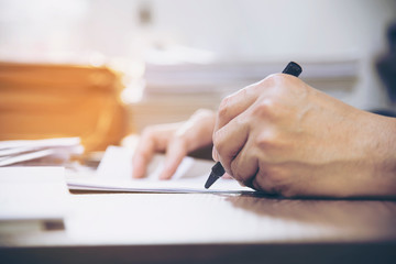 Businessman holding pen while working with document - business people working concept