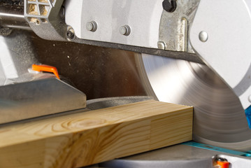 Closeup of professional cabinet makers working with electric circular saw at woodworking workshop....