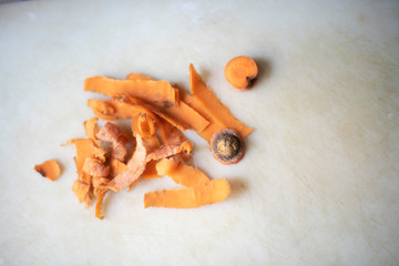 Left over peels of a carrot on a white chopping board in an Indian kitchen.