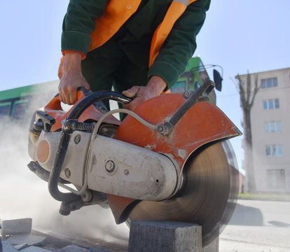 A worker saws a block with a circular saw, close-up.