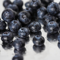 ripe blueberries on a light background in drops
