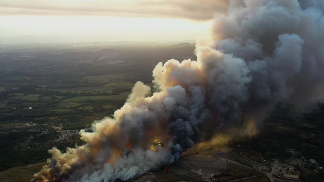 Pollution, Global warming and Climate change, a huge dark wildfire smoke cloud caused by a wild fire, sunny day, in Queensland, Australia - Aerial, orbit, drone shot