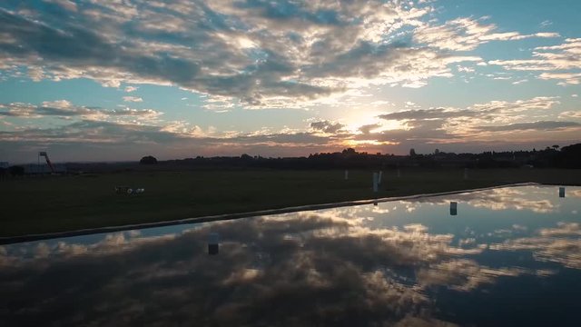 Rotating around a parachute airstrip at high speed, with water reflection and sunset light, national parachuting center, boituva, são paulo