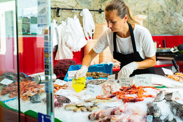 Saleswoman working at seafood showcase