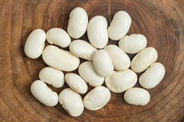 Raw dry beans on wooden background. Healthy, organic and delicious haricots. Legumes with high nutritional value. Top view, flat lay composition.