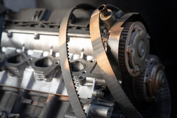 Stack of old timing belt and car engine.Automobile spare parts with sunlight.Car accessories in the garage.Car service, repair, maintenance concept.
