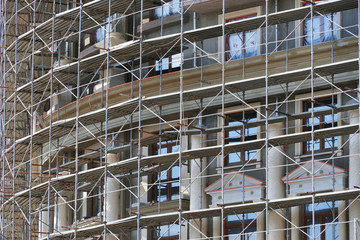 scaffolding at the facade of a building under construction, multi-storey building, without people