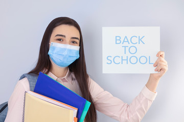 High school girl with mask on her showing back to school message