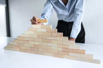 Risk To Make Business Growth Concept With Wooden Blocks, hand of business woman has piling up and...