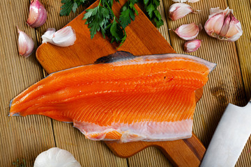 Close up of tasty raw sea trout fillet on wooden desk