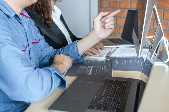 Two professional programmer cooperating and working on web site project in a software developing on desktop computer at company, codes and typing data code, Programming with HTML, PHP and javascript