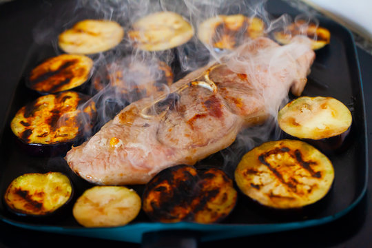 Delicious pork with eggplant frying on grill, steam