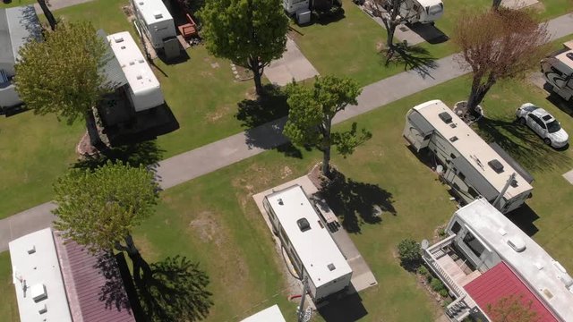 RVs, travel motorhome park models and fifth wheels in campground, rising aerial