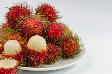 Rambutan is a fruit with red and green skin and fur. The flesh is white