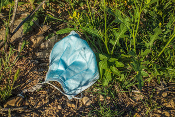 Surgical mask lying in the field like garbage.