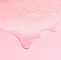 Cosmetische heldere vloeibare transparante crème. Huidverzorgingsproduct op roze achtergrond. Ruimte kopiëren.