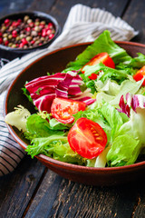 Healthy salad, leaves mix salad (mix micro greens, cucumber, tomato, onion, other ingredients) keto or paleo diet. food background copy space 