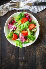 Healthy salad, leaves mix salad (mix micro greens, cucumber, tomato, onion, other ingredients) keto or paleo diet. food background copy space 