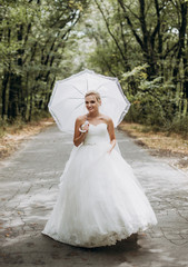 Fototapeta na wymiar beautiful bride portrait with umbrella in park