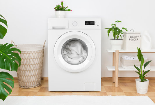 Simple interior of home laundry room with modern washing machine