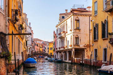 Canal and its colorful facades and boats in Venice in Veneto, Italy