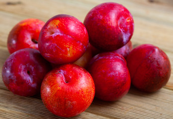 Fototapeta na wymiar Sweet red plums on wooden table