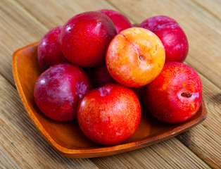 Sweet red plums on wooden table