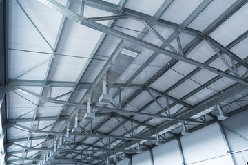 Ceiling installation at a manufacturing plant. Metal construction, details. Ventilation and lighting.