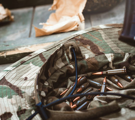 Machine gun cartridges in a soldier's hat. Copy space for text. Close-up. Soft focus. 