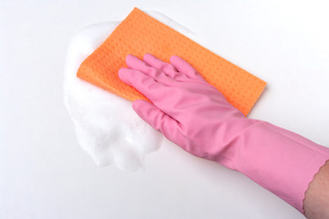 Hand in rubber glove with a cellulose sponge, cleaning surface.