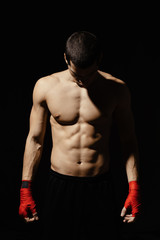 Fototapeta na wymiar Caucasian boxer getting ready for the next fight. The concept of sport, healthy lifestyle, sports nutrition. Beautiful abs.