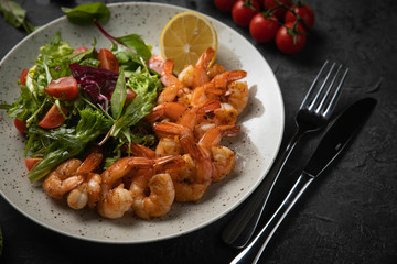 salad with shrimp and avocado on black background