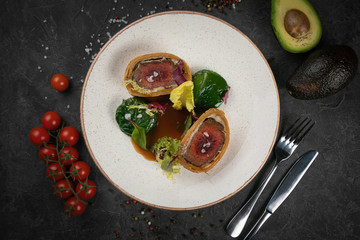 meat on a plate with spinach and avocado