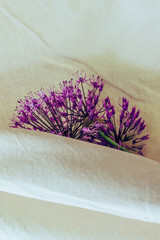 
Purple flowers of wild onion allium on a background of light cotton fabric