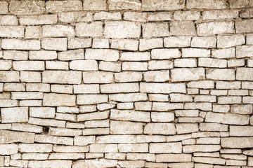 Stary kamienny mur. Tło - ściana z białych wapiennych cegieł.