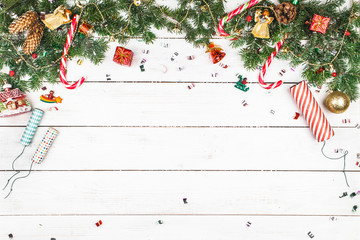 Christmas decoration in the form of branches of spruce, garland, caramel cane on a white wooden...